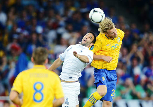 Adil Rami, Frankrike, i en luftduell med Ola Toivonen,