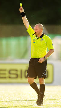 Mattias Nyman, domare, delar ut ett gult kort