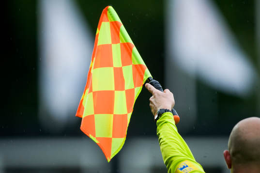 Flagga, assisterande domare vinkar