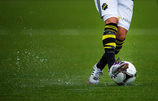 En AIK-spelare kontrollerar bollen på