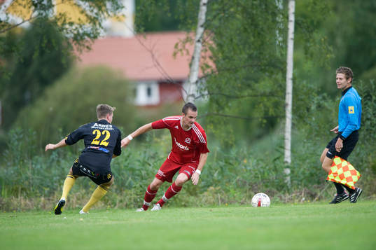 Idyllisk idrottsplats, assisterande domare, skog, hus