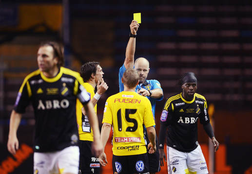Martin Hansson, domare, delar ut gult kort