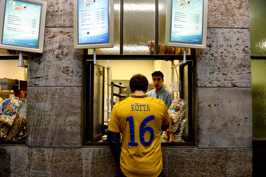 En svensk supporter förbereder sig genom att köpa mat på