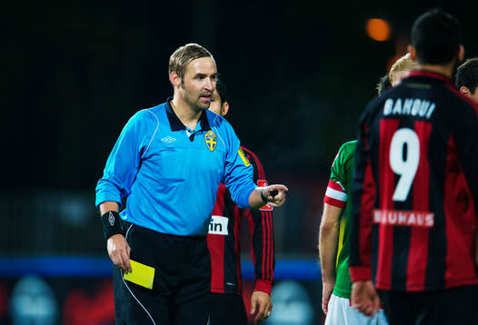 Jim Petersson, domare, delar ut ett gult kort till en