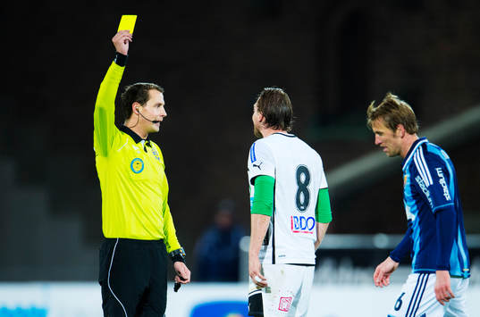 Andreas Ekberg, domare, delar ut ett gult kort till Richard