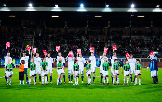 Djurgårdens spelare håller upp plakat för kampanjen "Ge