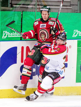 Christian Bäckman, Frölunda, tacklas upp mot sargen av