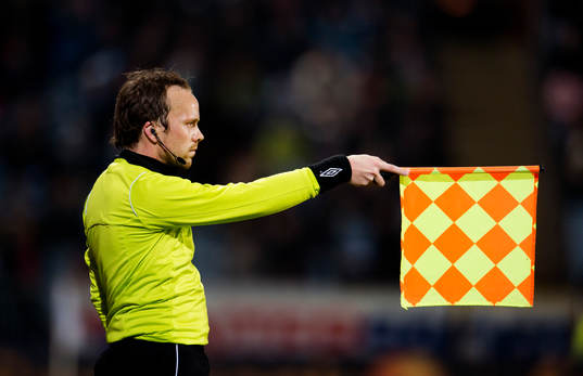 assisterande domaren vinkar av för offside när Wilton