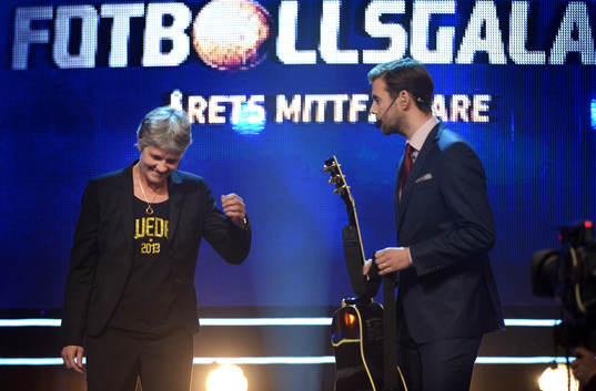 Pia Sunhage, förbundskapten får en gitarr av Pär
