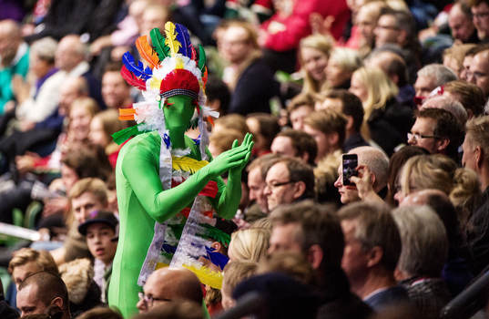 Supporter i grön kroppsstrumpa och fjädrar på huvudet