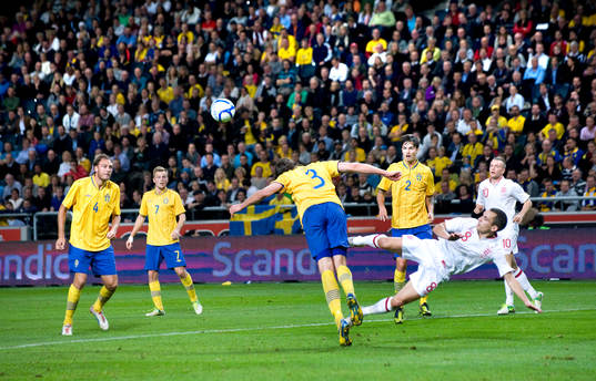 Jonas Olsson, Sverige, nickar undan framför Leon Osman,