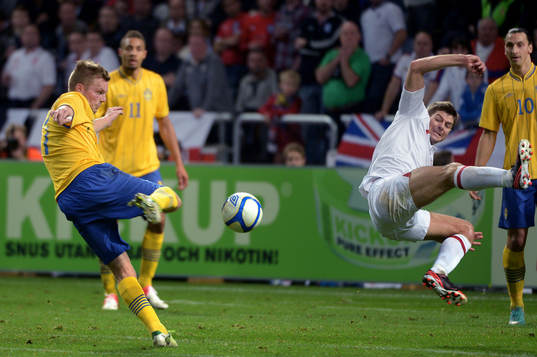 Sebastian Larsson, Sverige, testar skott. Steven Gerrard,
