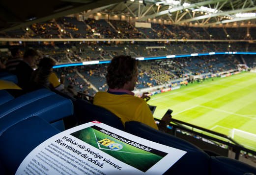 En loge med många personer i svenska tröjor