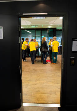 En loge med många personer i svenska tröjor