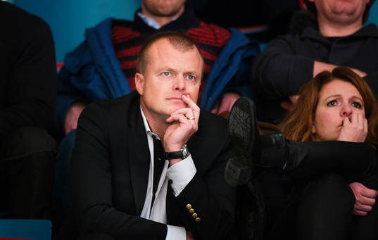 Anders Gozzi, sportchef AIK, sitter på läktaren och