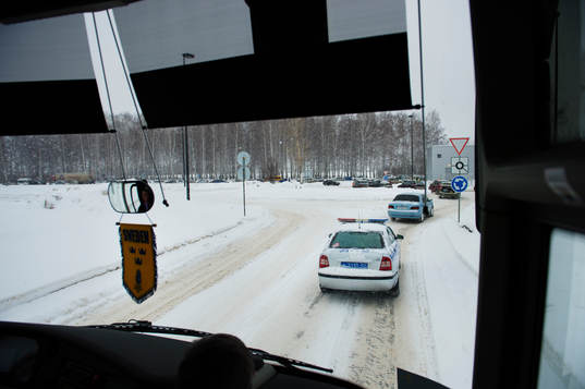 En polisbil eskorterar Sveriges spelarbuss genom Ufa