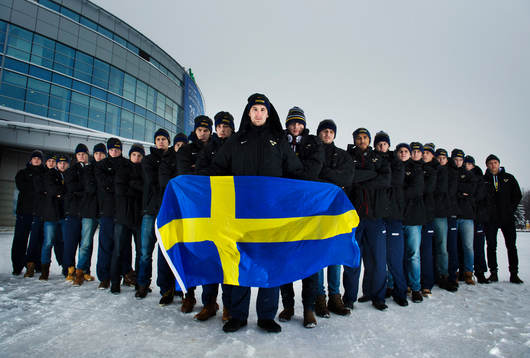 Sveriges lag uppställda med en flagga, från vänster till