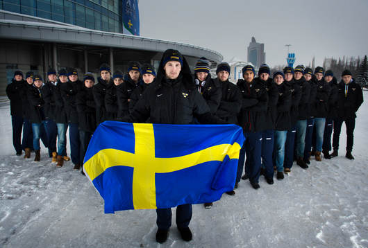 Sveriges lag uppställda med en flagga, från vänster till