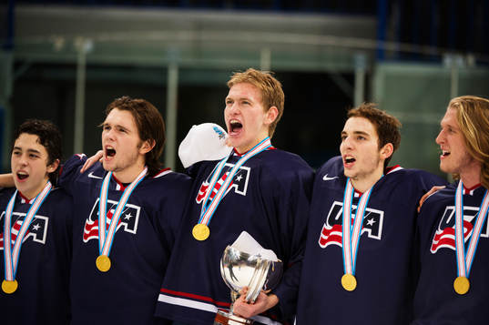 Spelare i USA håller i pokalen och sjunger sin