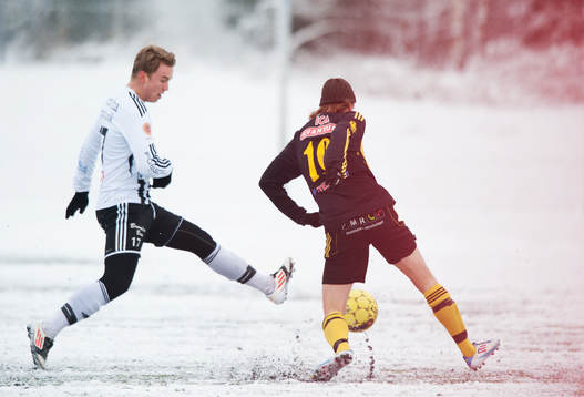 Fot, fotboll, fotbollsskor. Snö, snöig konstgräsplan.