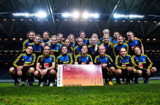 Damlandslaget poserar med biljetten för finalen på