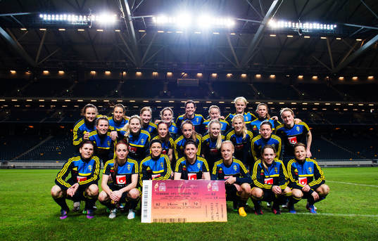 Damlandslaget poserar med biljetten för finalen på