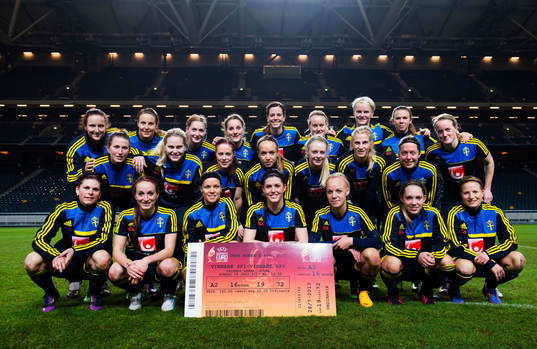Damlandslaget poserar med biljetten för finalen på