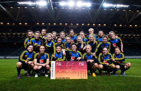 Damlandslaget poserar med biljetten för finalen på