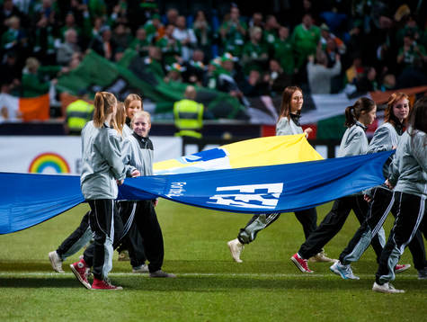Ungdomar bär in en flagga före matchstart