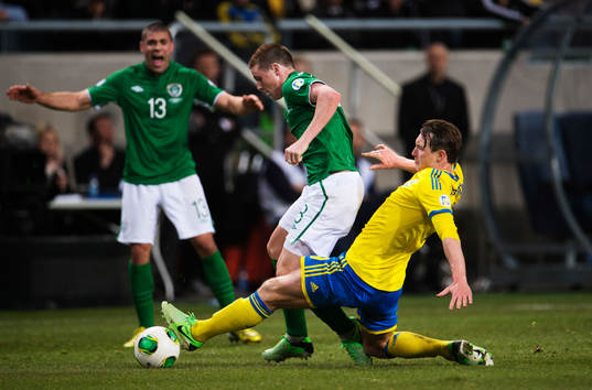 Kim Källström, Sverige, tacklar James McCarthy, Irland