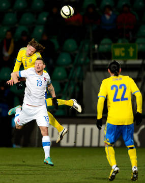 Jonas Olsson, Sverige, i luftduell med Filip Holo