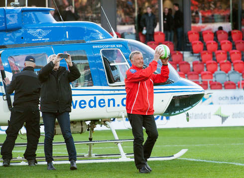 Helikopter landar på Myresjö arena i solnedgången,