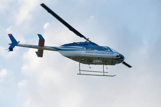 Helikopter lyfter mot blå himmel