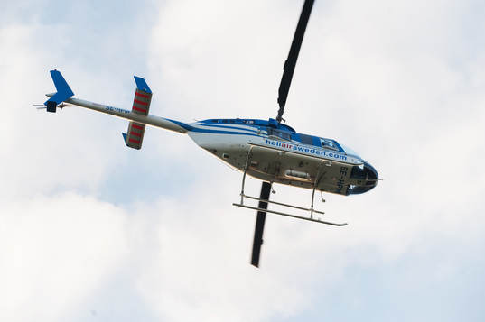 Helikopter lyfter mot blå himmel