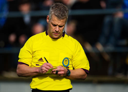 Tobias Mattsson, domare, antecknar på ett gult kort