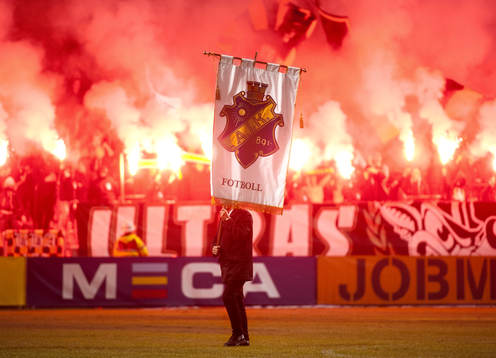 Man med AIK-flagga går över planen
