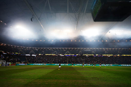 Rök från bengaleldar i AIK:s klack stiger mot taket i