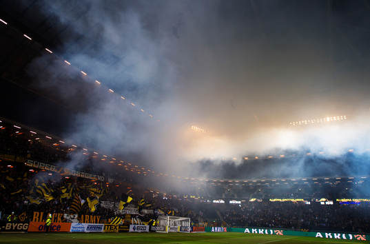 Rök från bengaleldar i AIK:s klack stiger mot taket i