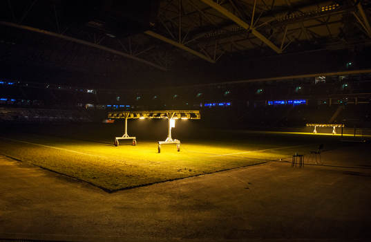 Artificiellt ljus belyser gräset på fotbollsplanen på