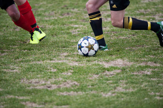 Gräs, uselt vårgräsmatta, fot, fötter, fotboll,