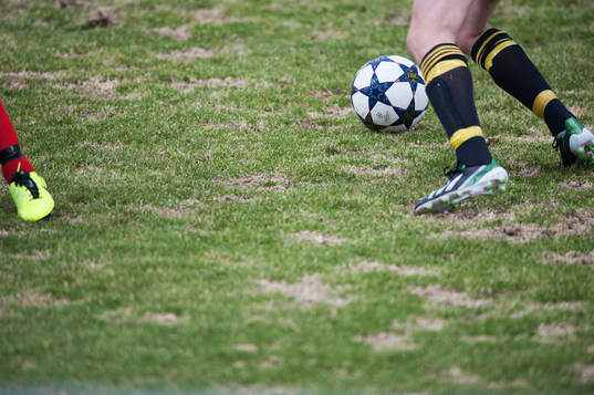 Gräs, uselt vårgräsmatta, fot, fötter, fotboll,