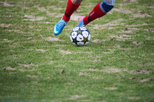 Gräs, uselt vårgräsmatta, fot, fötter, fotboll,