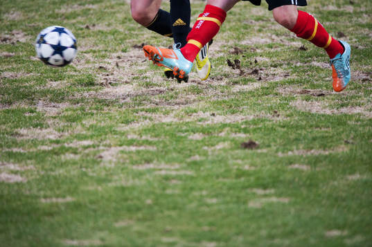 Gräs, uselt vårgräsmatta, fot, fötter, fotboll,