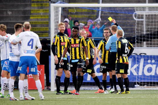 Johan Hamlin, domare, delar ut ett gult kort