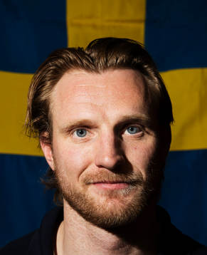 Staffan Kronwall poserar framför en svensk flagga när det