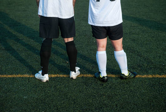 Två spelare i korplaget Handikappbadets FC med olika färg