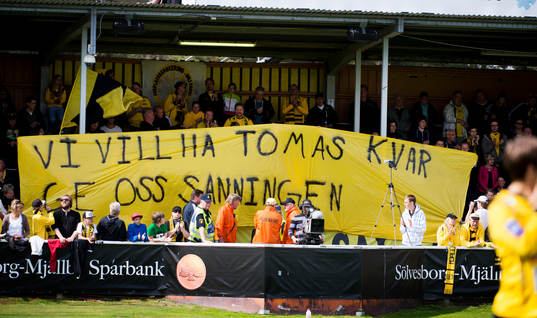 supportrar till Mjällby håller upp en banderoll som