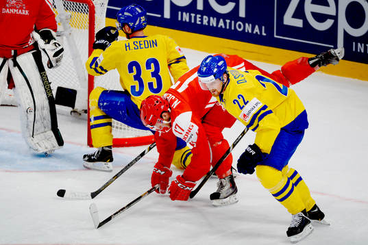 Henrik Sedin och Daniel Sedin stoppas av Joel Riddez  i
