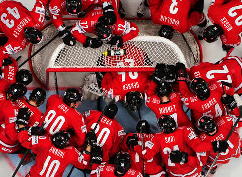 Schweiz spelare är samlade runt målvakten Martin Gerber