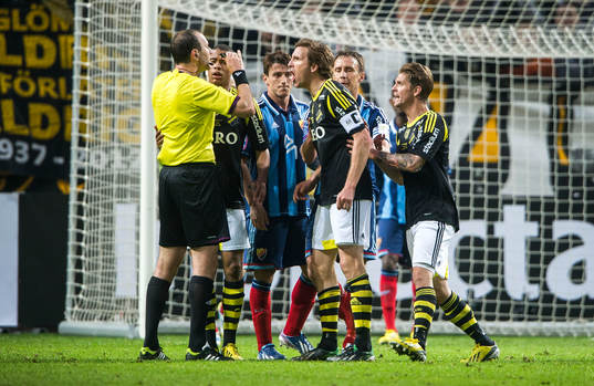 Domaren Jonas Eriksson står med pipan i munnen och AIK